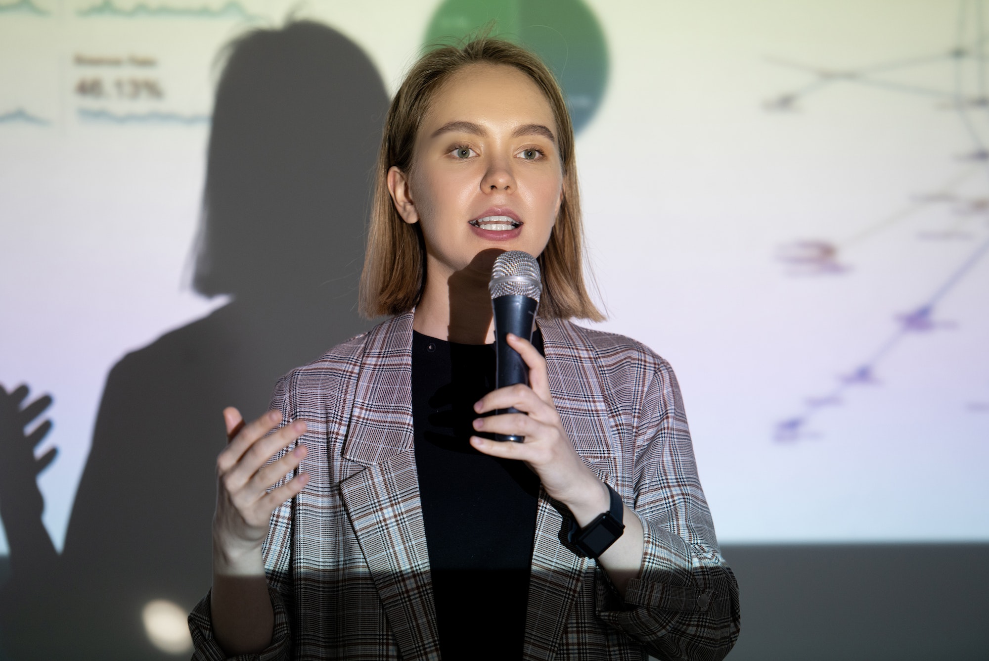 Confident young woman speaking into microphone